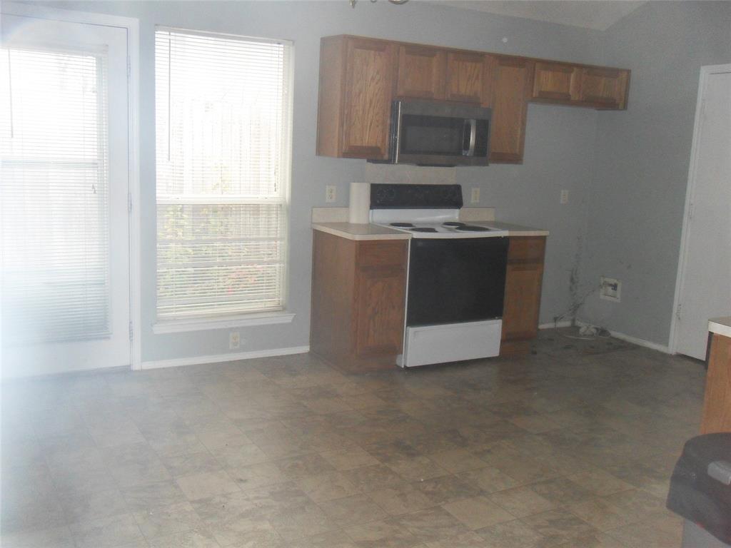 817 Cruise Street Denton, TX 76207 - Photo 4 of 17 a kitchen with a stove and a microwave