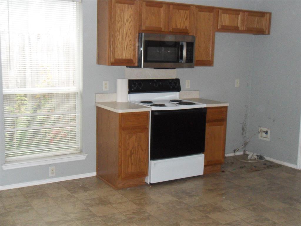 817 Cruise Street Denton, TX 76207 - Photo 5 of 17 a view of kitchen with microwave stove and cabinets