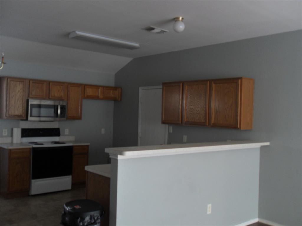 817 Cruise Street Denton, TX 76207 - Photo 8 of 17 a kitchen with kitchen island a sink stainless steel appliances and cabinets