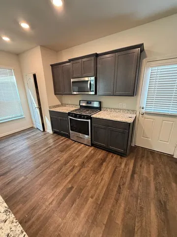 a kitchen with stainless steel appliances wooden cabinets and a stove top oven