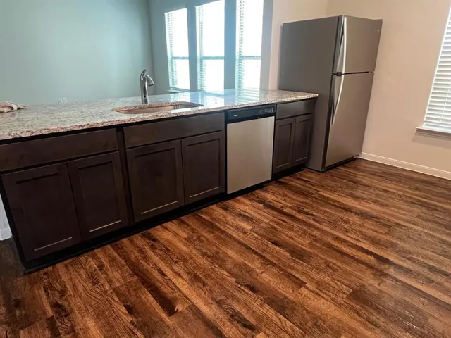 a room with granite countertop wooden cabinets and a sink
