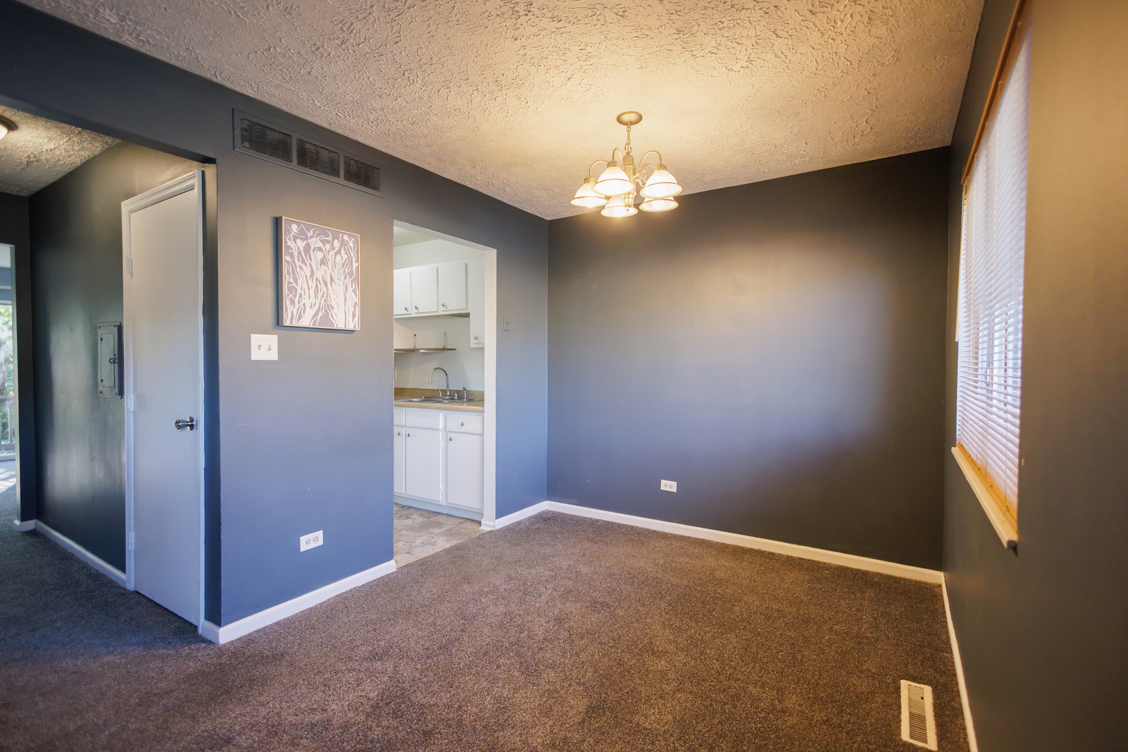 1119 South Curtis Avenue, Unit F62 Kankakee, IL 60901 - Photo 4 of 32 an empty room with chandelier fan and windows