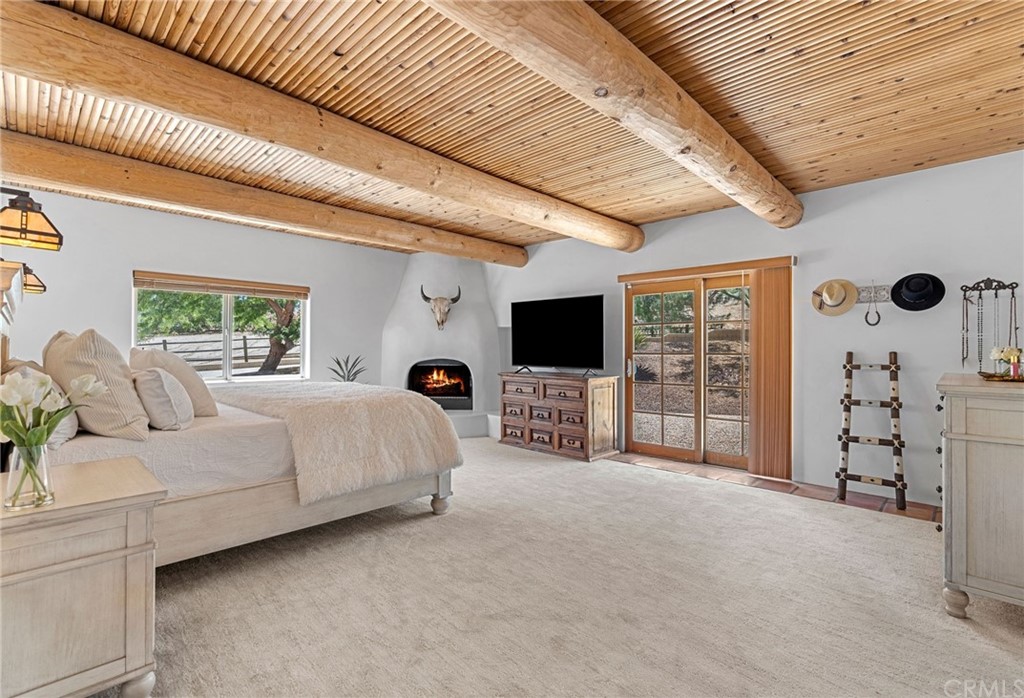 30620 Jedediah Smith Road Temecula, CA 92592 - Photo 18 of 36 a spacious bedroom with a bed a flat screen tv and a large window