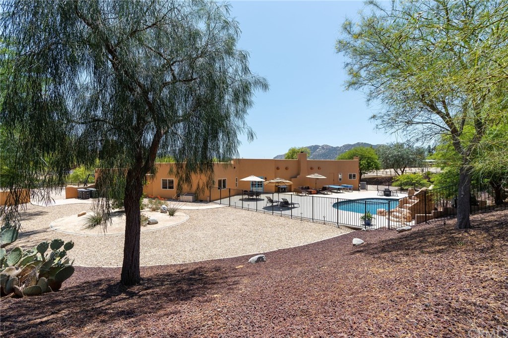 30620 Jedediah Smith Road Temecula, CA 92592 - Photo 31 of 36 a view of a backyard with a fire pit and a large tree