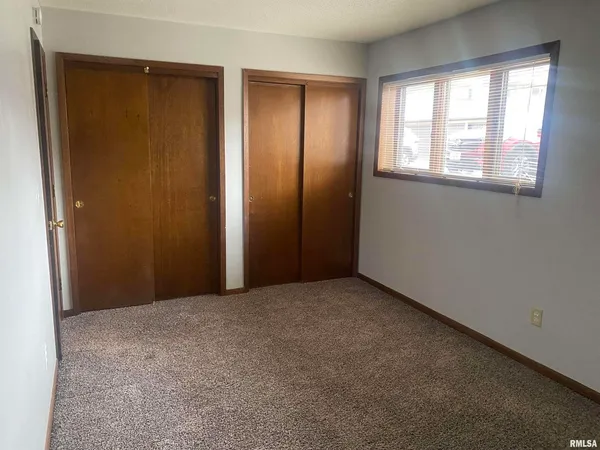 an empty room with windows and closet