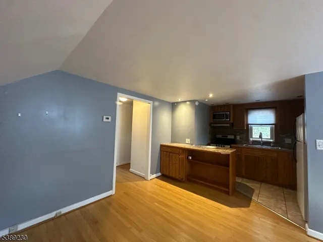 a view of living room with stainless steel appliances wooden floor and large window