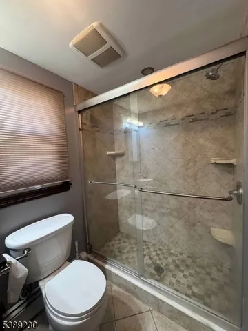 a white toilet sitting next to a bath tub and shower