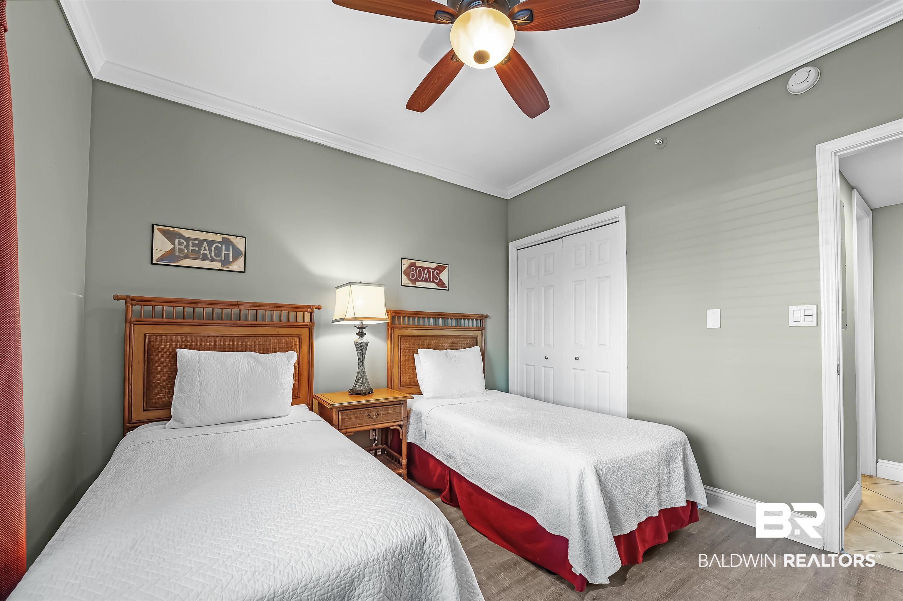 16287 Perdido Key Drive, Unit 105 Pensacola, FL 32507 - Photo 37 of 66 Bedroom featuring wood-finish flooring, a ceiling fan with integrated lighting, and crown molding