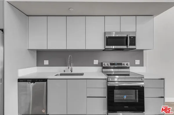 a kitchen with stainless steel appliances granite countertop a sink stove and microwave