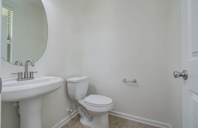 a bathroom with a toilet a sink and mirror