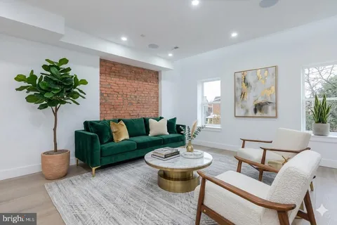 a living room with furniture potted plant and a table