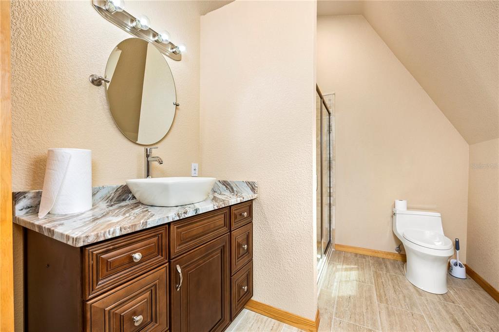 3897 Pinemount Road Lake City, FL 32024 - Photo 50 of 70 a bathroom with a granite countertop sink a toilet and a mirror