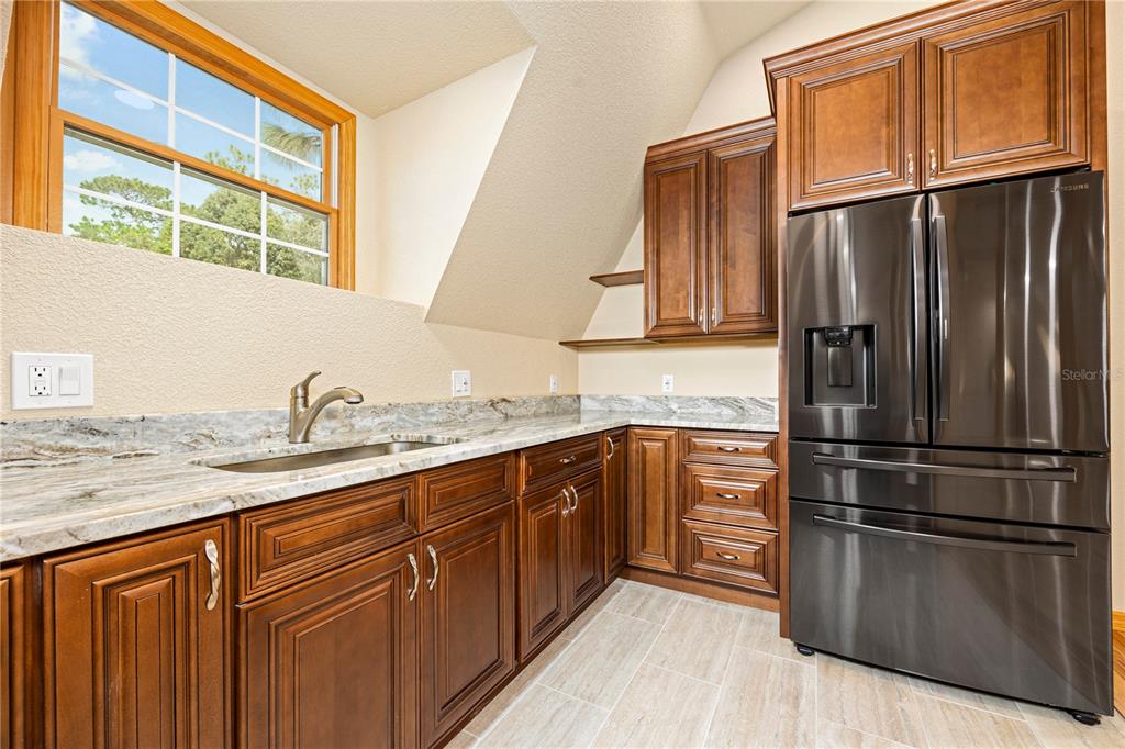 3897 Pinemount Road Lake City, FL 32024 - Photo 53 of 70 a kitchen with granite countertop stainless steel appliances a refrigerator sink and cabinets