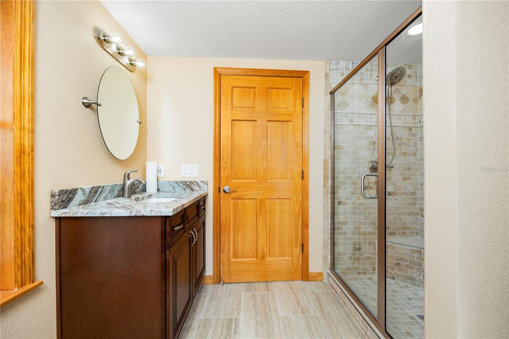 3897 Pinemount Road Lake City, FL 32024 - Photo 64 of 70 a bathroom with a granite countertop shower a sink and a mirror