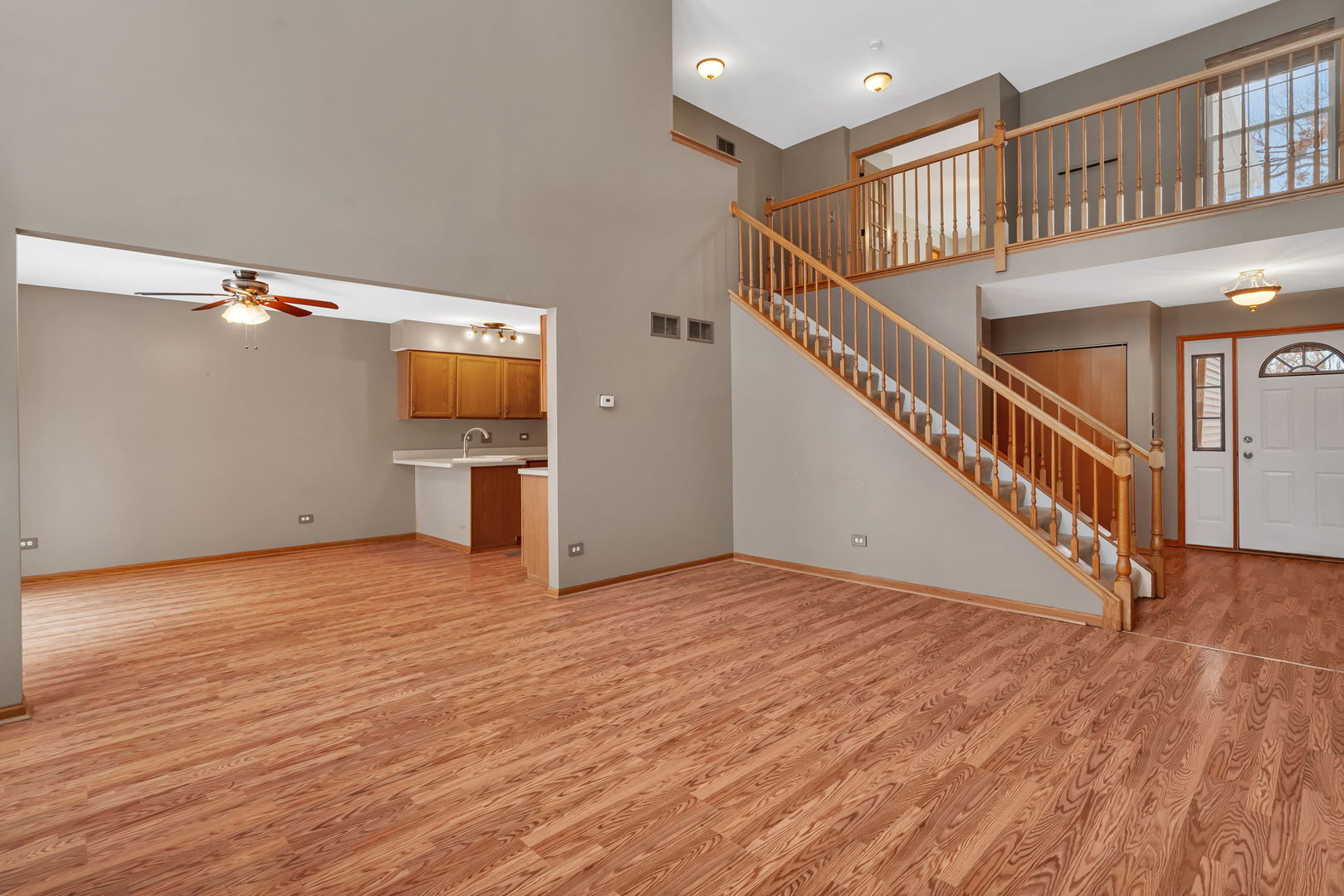 936 Treeline Court Lockport, IL 60441 - Photo 13 of 29 a view of an empty room with wooden floor stairs and a kitchen view