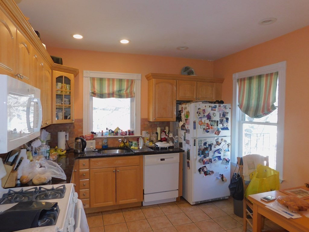 145 Lagrange Street Boston, MA 02132 - Photo 15 of 37 a kitchen with a refrigerator and a stove top oven