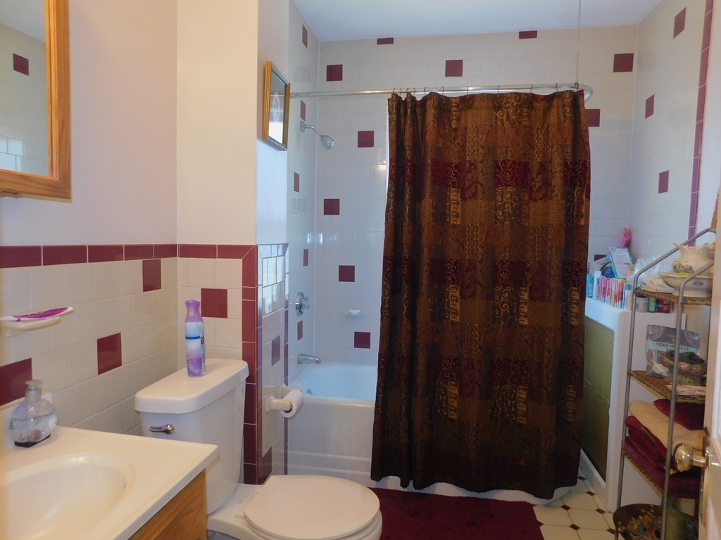 145 Lagrange Street Boston, MA 02132 - Photo 17 of 37 a bathroom with a toilet and a shower curtain