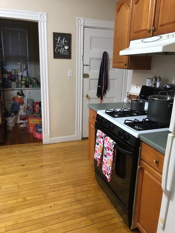 145 Lagrange Street Boston, MA 02132 - Photo 6 of 37 a kitchen with stainless steel appliances granite countertop a stove a sink and a microwave