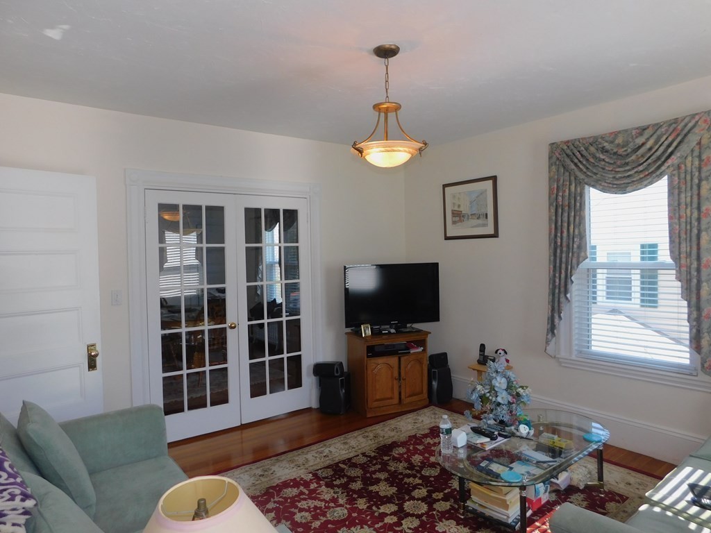 145 Lagrange Street Boston, MA 02132 - Photo 7 of 37 a living room with furniture a window and a flat screen tv