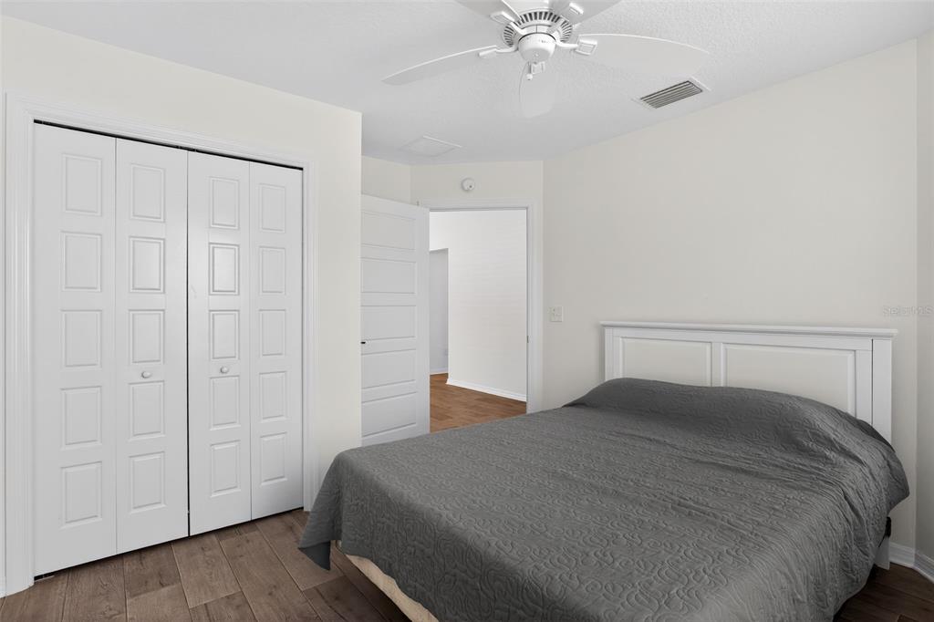 6273 Windham Way The Villages, FL 32163 - Photo 15 of 32 a bedroom with a large bed and a chandelier fan