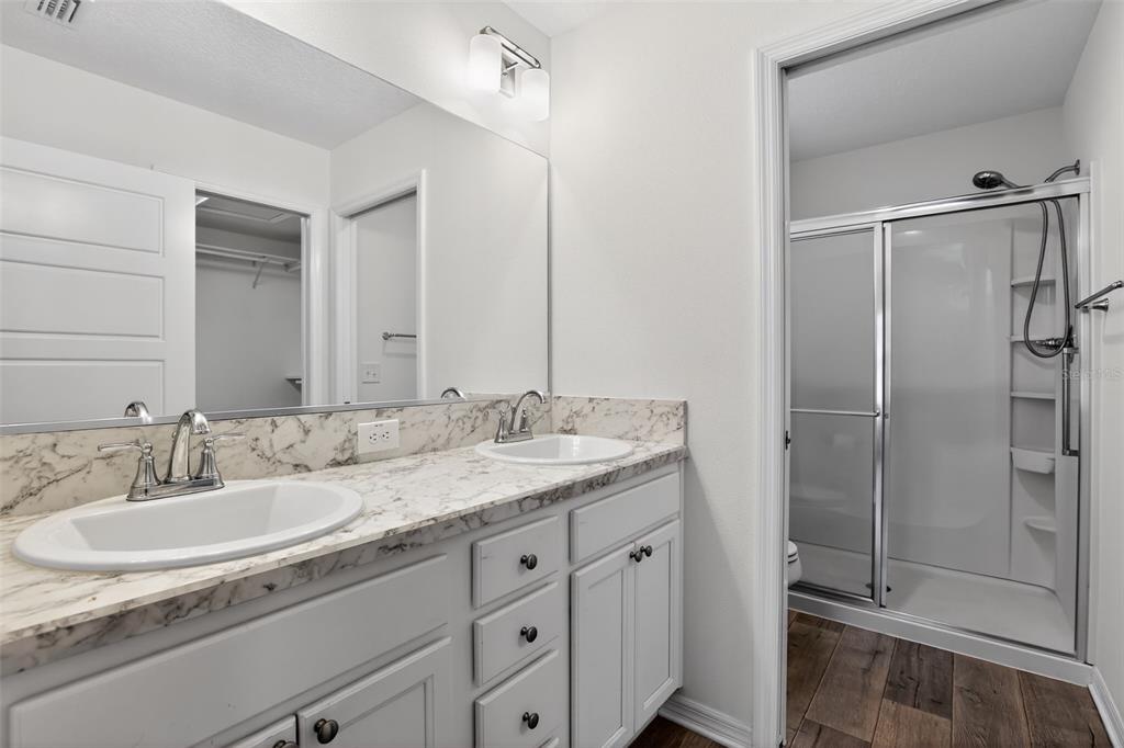 6273 Windham Way The Villages, FL 32163 - Photo 21 of 32 a bathroom with a granite countertop sink a mirror and a shower
