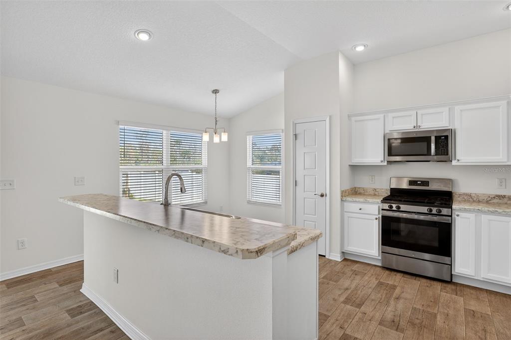 6273 Windham Way The Villages, FL 32163 - Photo 10 of 32 a kitchen with stainless steel appliances granite countertop a sink a stove and a refrigerator