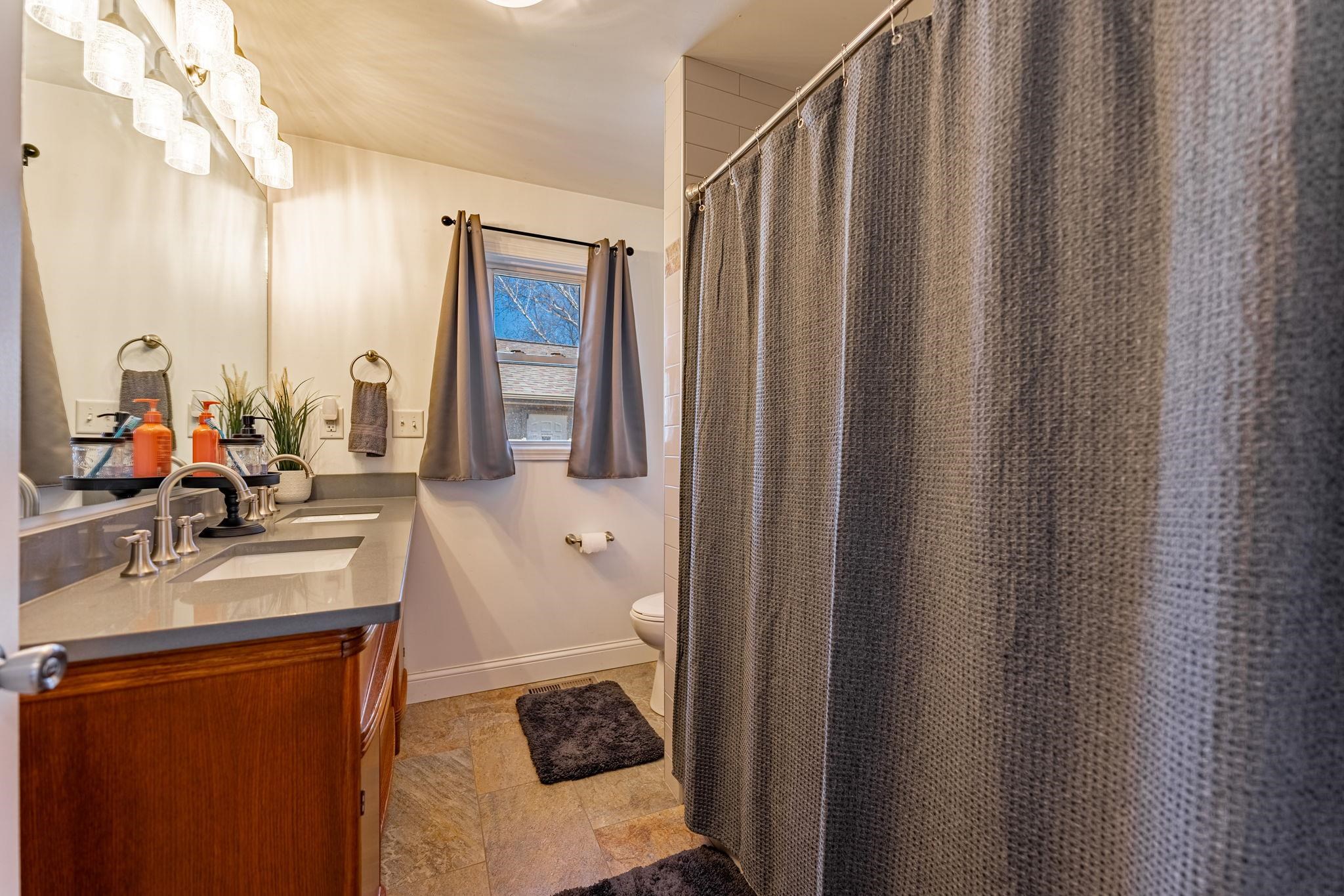 6912 Elevator Road Roscoe, IL 61073 - Photo 19 of 43 a en suite bathroom with a sink a mirror and a shower