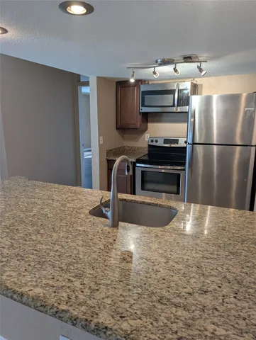 a kitchen with kitchen island a stove and a refrigerator
