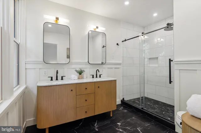 a bathroom with double vanity and a mirror