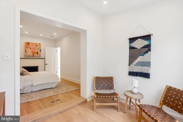 a living room with furniture and a painting on the wall