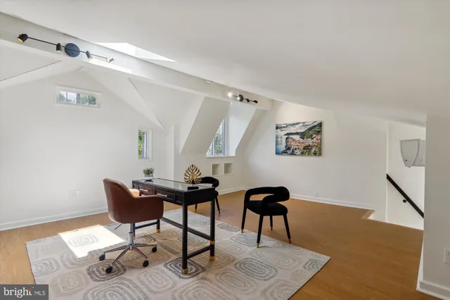 a view of a workspace with furniture and wooden floor