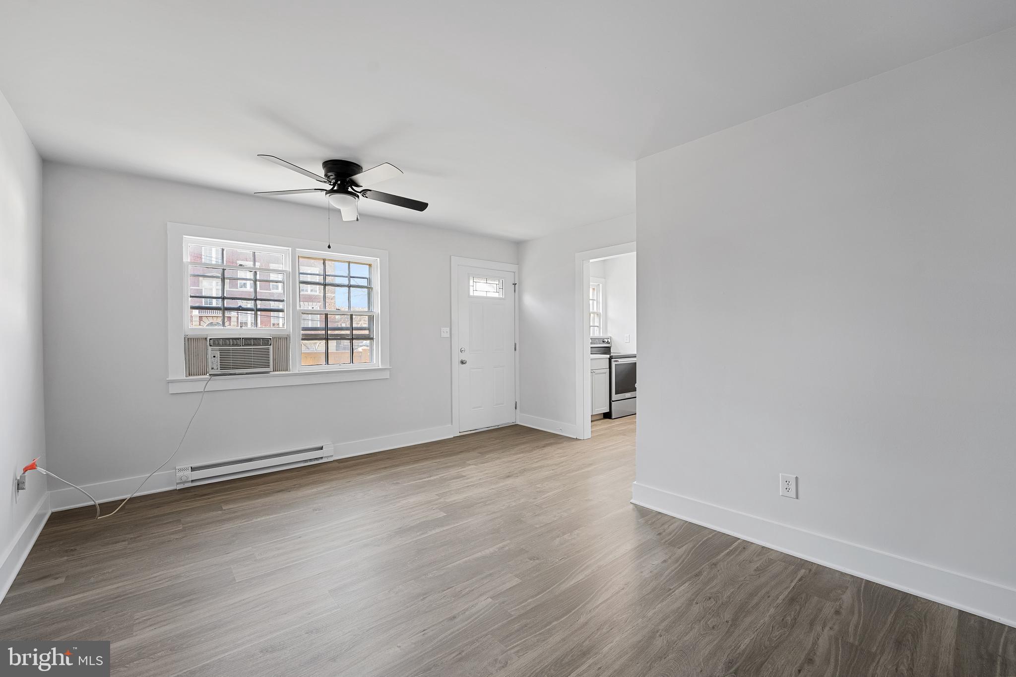 1117 Caroline Street, Unit E Fredericksburg, VA 22401 - Photo 5 of 17 an empty room with wooden floor and windows
