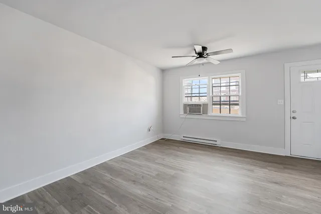 an empty room with a window and a ceiling fan