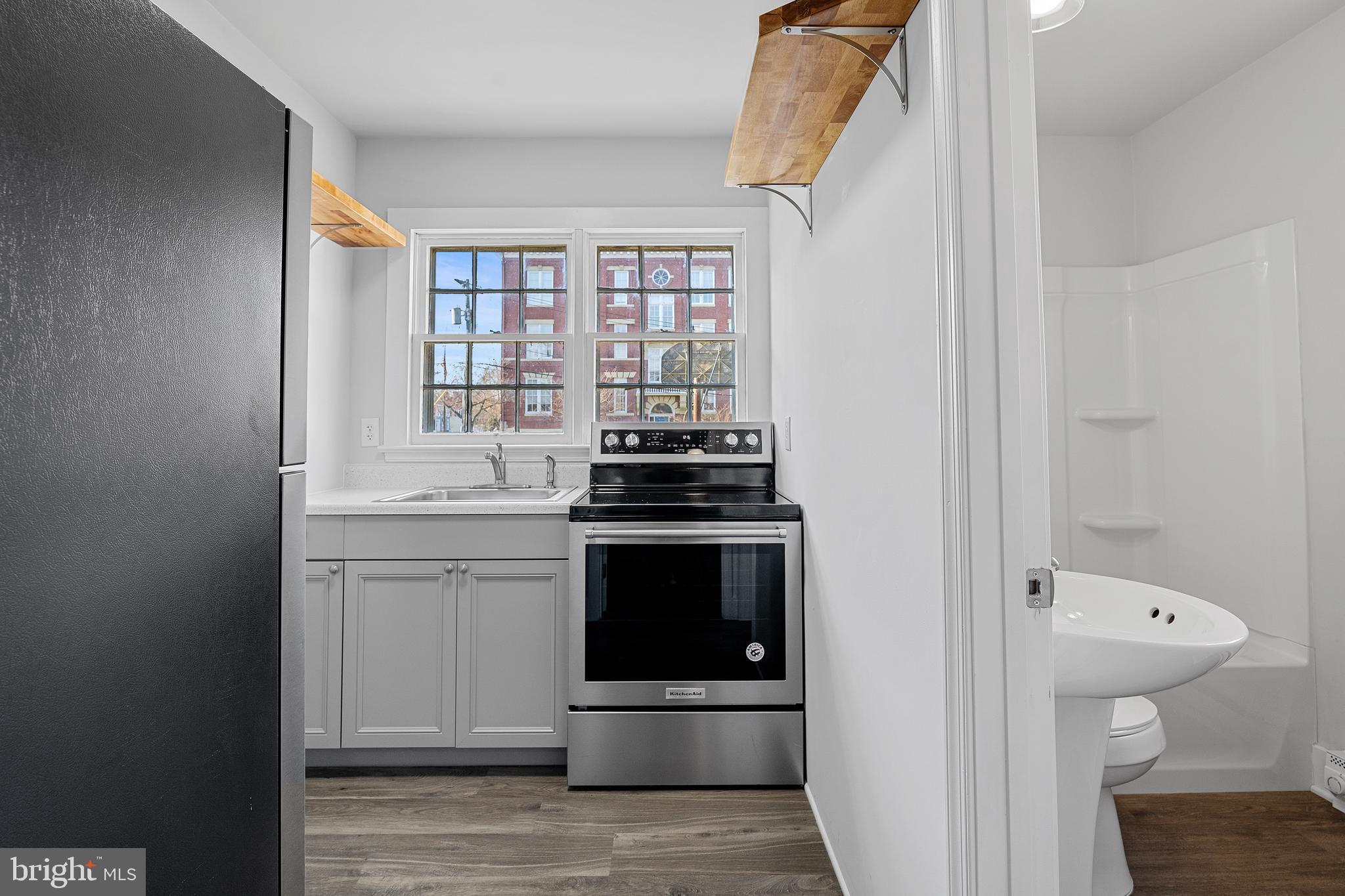 1117 Caroline Street, Unit E Fredericksburg, VA 22401 - Photo 8 of 17 a kitchen with a stove and a shower