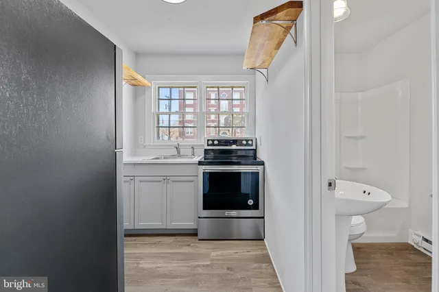 a kitchen with a refrigerator and a stove top oven