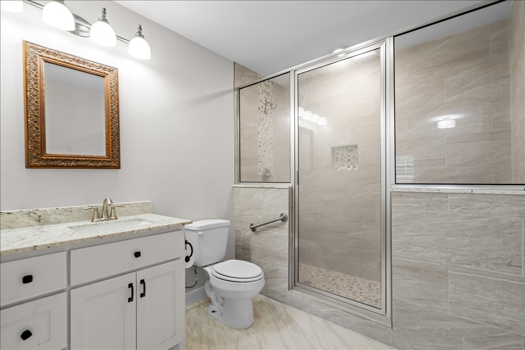 608 Whistleville Road Flatonia, TX 78941 - Photo 10 of 26 The ensuite has a granite topped vanity and a massive walk-in shower featuring a built-in niche, and a beautiful pebble-tile floor.