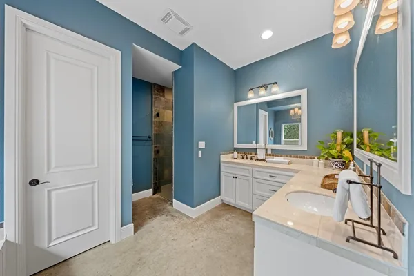 a spacious bathroom with a granite countertop sink a mirror and a bathtub