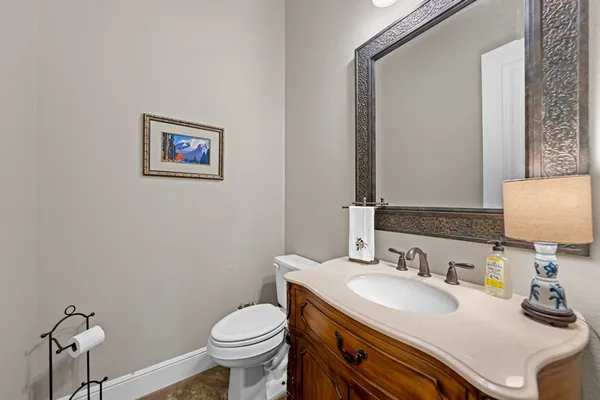 a bathroom with a granite countertop toilet sink and mirror