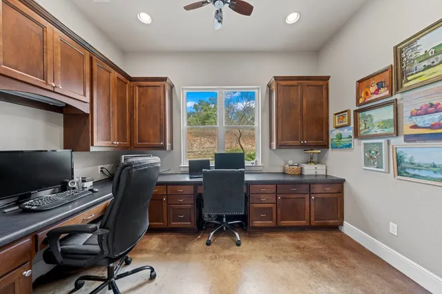 a view of a workspace with furniture and a window