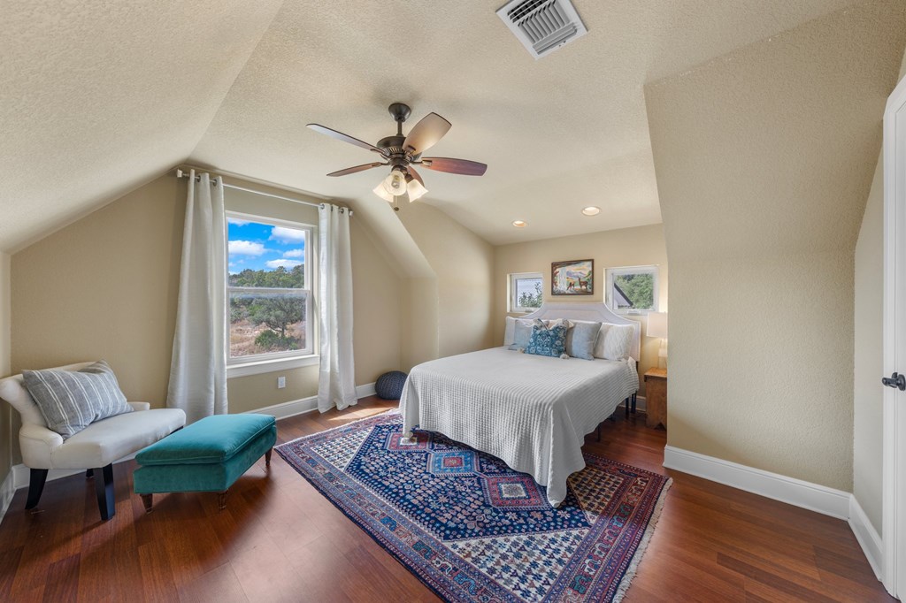 151 Kerr Canyon Pass South Kerrville, TX 78028 - Photo 22 of 45 a spacious bedroom with a bed a couch and a window