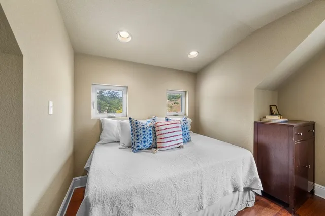 a bedroom with a large bed and wooden floor