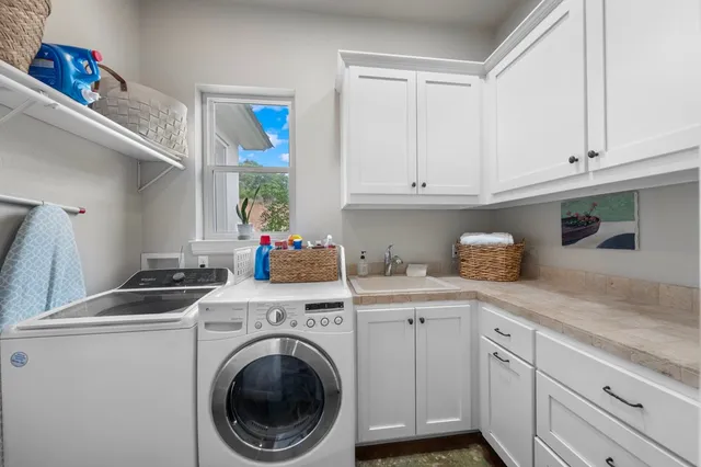 a utility room with sink dryer and washer