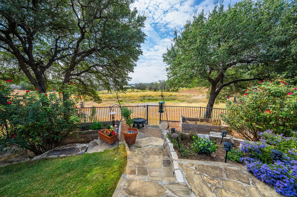 151 Kerr Canyon Pass South Kerrville, TX 78028 - Photo 31 of 45 a view of swimming pool with outdoor seating and a garden
