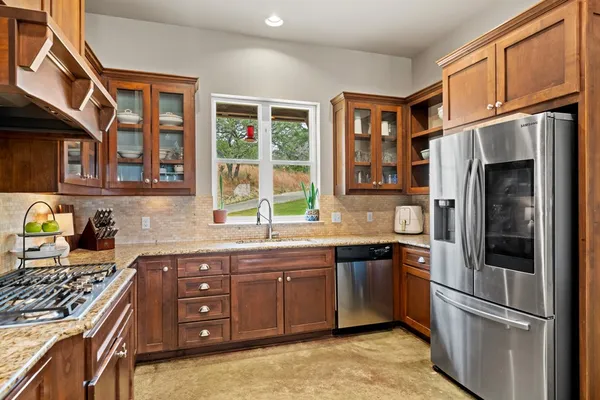 a kitchen with stainless steel appliances granite countertop a refrigerator stove and sink