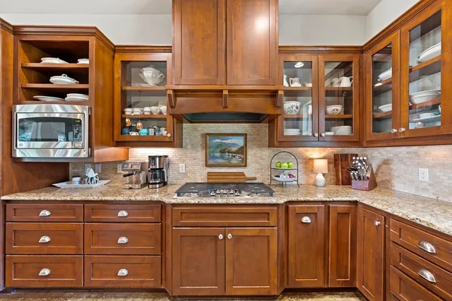 a kitchen with granite countertop a oven and cabinets