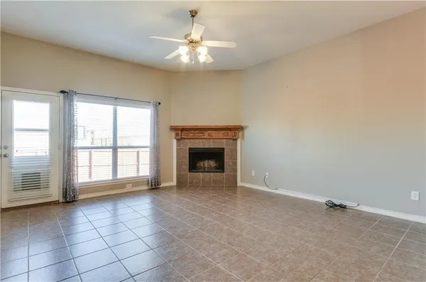an empty room with windows and fireplace