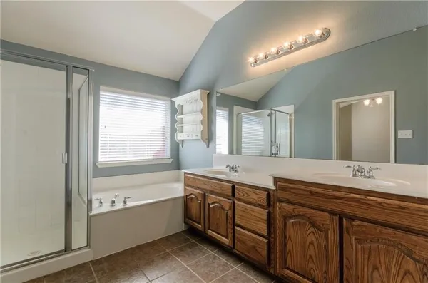 a bathroom with a granite countertop sink mirror and a bathtub
