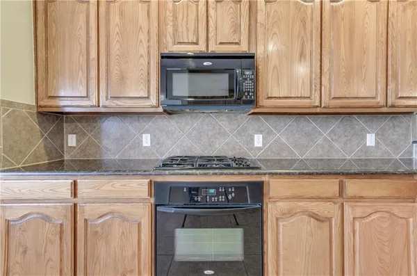 a kitchen with granite countertop white cabinets and stainless steel appliances
