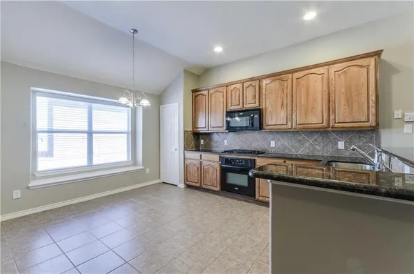 a kitchen with stainless steel appliances granite countertop a stove a sink and a microwave