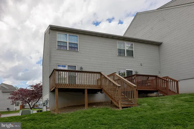 a view of a house with a yard and deck